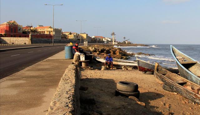 Dos hombres cuidan sus embarcaciones en medio de la cuarentena nacional por coronavirus en Cartagena (Colombia). (EFE/ Ricardo Maldonado Rozo).