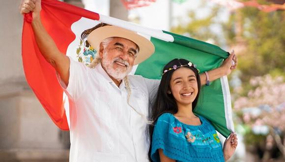 La gente disfruta del día festivo en México. Aquí una menor y un hombre sostienen la bandera tricolor (Foto: Freepik)