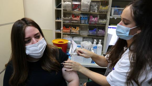 Personal sanitario administra una tercera dosis de la vacuna Pfizer-BioNtech COVID-19 a una mujer en Jerusalén, Israel, el 20 de agosto de 2021. (AHMAD GHARABLI / AFP).