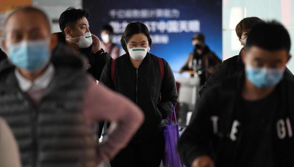 Los pasajeros usan mascarilla como medida preventiva contra el coronavirus cuando llegan de un vuelo en el Aeropuerto de Beijing. (AFP).