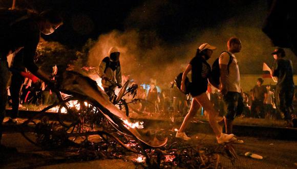 La gente prende fuego a una barricada de ramas durante una protesta contra la brutalidad policial en Cali, Colombia, el 21 de septiembre de 2020. (Luis ROBAYO / AFP).