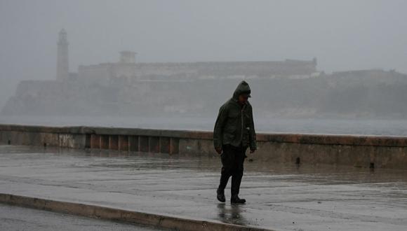 Un hombre camina por el Malecón de La Habana el 27 de septiembre de 2022, durante el paso del huracán Ian por Cuba.
(YAMIL LAGE / AFP).