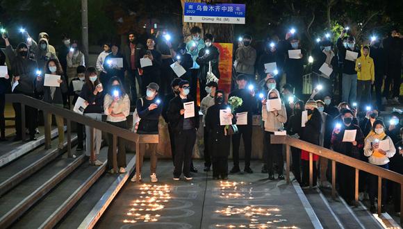 Las personas sostienen hojas de papel en blanco en protesta por las muertes causadas por un incendio en un complejo de apartamentos en Urumqi, Xinjiang, China, en la Biblioteca Langson en el campus de la Universidad de California, Irvine, en Irvine, California, el 29 de noviembre de 2022. (Foto de Frederic J. BROWN / AFP)