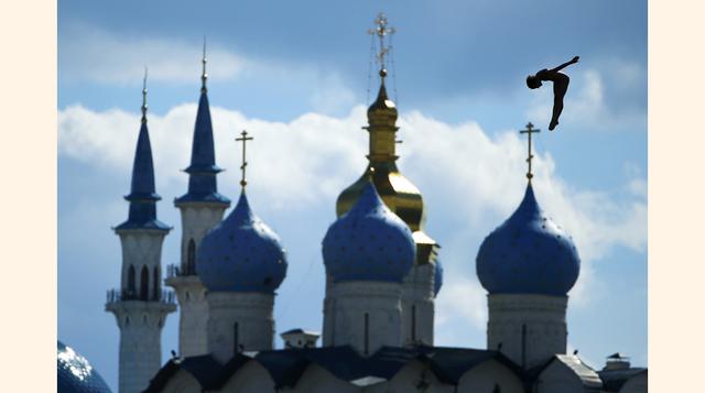 Un nadador salta 27m en la competición masculina en el Campeonato Mundial de Natación en Kazán, Rusia. En la foto, en el fondo se observa la mezquita Kul Sharif (L) y la Catedral de la Anunciación. (Foto: Reuters / Hannibal Hanschke)