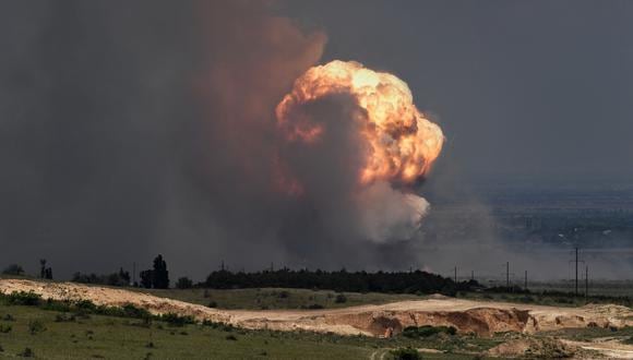 Una imagen muestra la detonación de municiones causada por un incendio en un campo de entrenamiento militar en el distrito Kirovsky de Crimea. (Foto de Viktor KOROTAYEV / Kommersant Photo / AFP)
