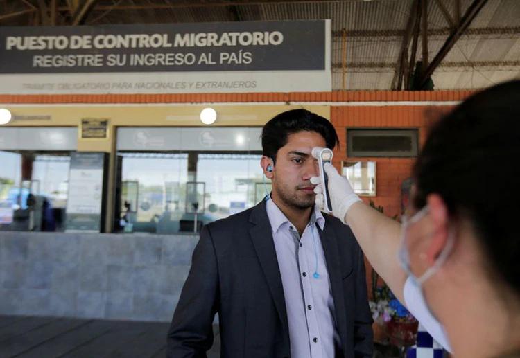 Imagen de archivo de un trabajador de la salud tomando la temperatura de un hombre en el paso fronterizo de Puerto Falcón, Paraguay, Marzo 11, 2020. REUTERS/Jorge Adorno
