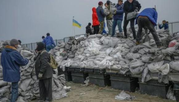 Unos ciudadanos llenan sacos con arena para llevarlos al frente en la playa de la ciudad de Odesa, el 7 de marzo de 2022 al sur de Ucrania. (Foto: AFP)