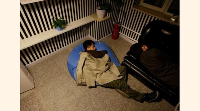 Yu Xiaojian (a la izq.) y Li Yan, empleados del Grupo Goopal, toman una siesta durante un descanso en el trabajo cerca de la medianoche en Pekín, China. (Foto: Reuters)