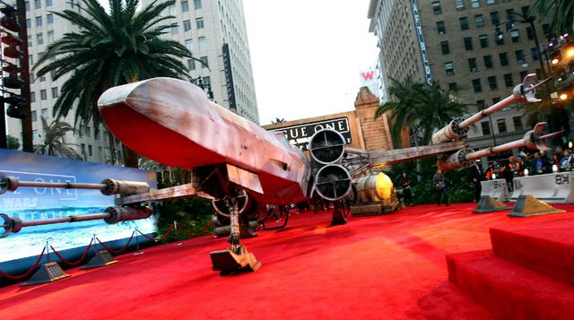 En el estreno mundial de Rogue One: A Star Wars Story, un X-Wing Fighter de tamaño real apareció estacionado en pleno Hollywood Boulevard, para deleite del público y los asistentes. (Foto: AFP).