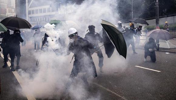 Un manifestante usa una raqueta de bádminton para lanzar una submunición de gas lacrimógeno contra la policía antidisturbios de Hong Kong durante una protesta en el distrito de Admiralty el 29 de setiembre. (Foto: Bloomberg)