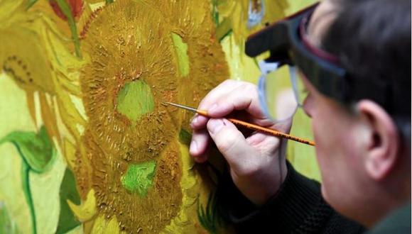 El especialista Rene Boitelle restaura el cuadro "Girasoles" de Vincent van Gogh en el Van Gogh Museum de Amsterdam, Holanda, el 24 de enero de 2019. (Foto: Reuters).