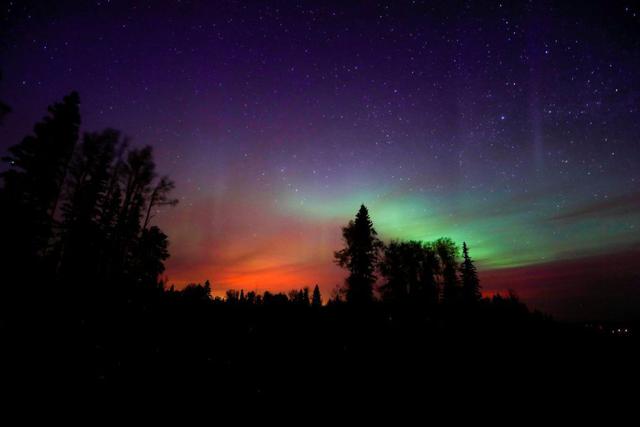 El color de un incendio forestal brilla bajo las auroras boreales en Alberta, Canadá. (Foto Reuters)