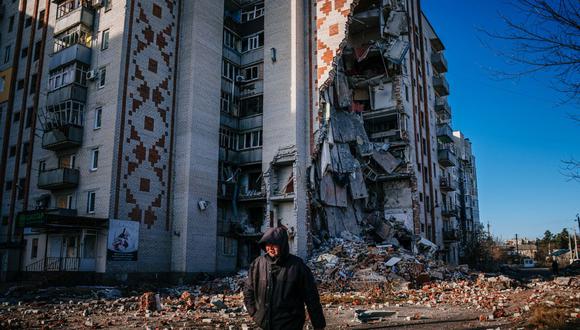 Un hombre camina junto a un edificio residencial destruido en la ciudad de Lyman, región de Donetsk, el 4 de enero de 2023, en medio de la invasión rusa de Ucrania. (Foto de Dimitar DILKOFF / AFP)