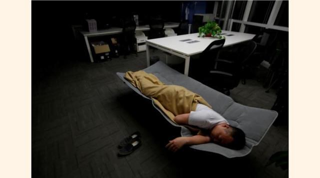 Ma Zhenguo, un ingeniero de sistemas de RenRen Credit Management Co., duerme en una cama plegable en su oficina después de terminar su trabajo durante la madrugada en Pekín, China. (Foto: Reuters)