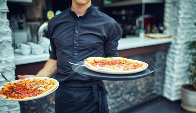 FOTO 16 | 16. Mesero. Si tomas diferentes turnos en la industria restaurantera puedes acomodar los horarios de tus clases y ganar un buen dinero extra considerando los sueldos base y las propinas. En Estados Unidos el sueldo promedio empieza en $5.20 la hora, más propinas. El trabajo no es nada fácil, porque no sólo tienes que tomar órdenes sino que debes llevar charolas llenas de comida a las mesas, limpiarlas, y en ocasiones, quedarte tarde para cerrar el local. Sin embargo, es una buena oportunidad para aprender a relacionarte con la gente, aprender cosas sobre servicio al cliente y claro, conseguir una que otra comida gratis. (Foto: Getty)
