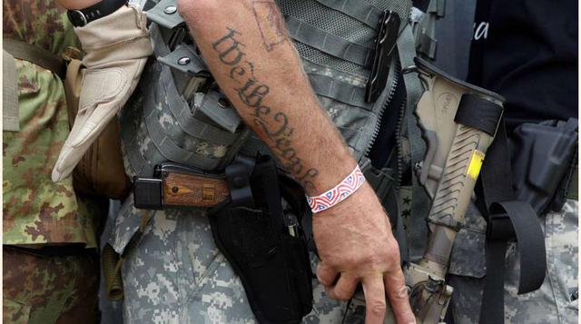FOTO 9 | Un tatuaje que reza "Nosotros, el pueblo" en el brazo de un miembro de las milicias durante un entrenamiento en combate en entornos cerrados.
