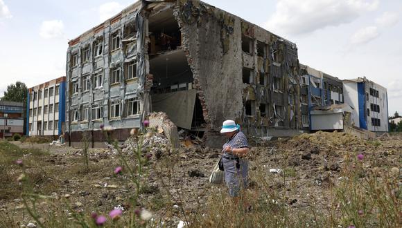 En esta foto de archivo tomada el 25 de julio de 2022, una mujer pasa frente a una escuela parcialmente destruida como resultado de un ataque con misiles en la ciudad de Kostyantynivka, región de Donetsk. (Foto: Anatolii Stepanov / AFP)