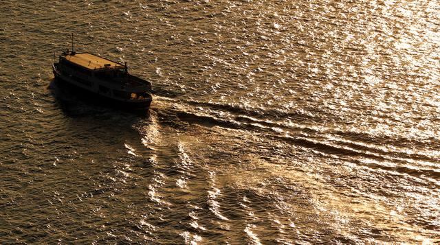 Un bote deja una estela mientras pasa por el New York Harbor. (Foto: Reuters)