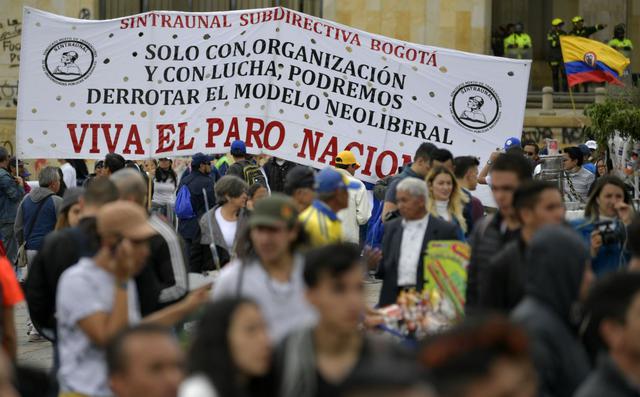 “Exijo al Gobierno que detenga la represión de las protestas. El principal problema es el Esmad, el punto principal que hay que exigir es el desmonte del Esmad que es una institución criminal que no asegura a nadie en las protestas pero sí ataca a los manifestantes”, dijo a Efe Jhonny Martínez, estudiante que llevaba una bandera de Chile en la marcha. (Foto: AFP)