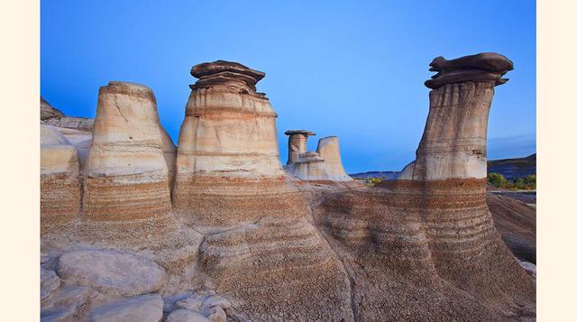 Hoodoos (Badlands, Alberta; Canadá). Una chimenea de hadas o hoodoo es una gran columna natural constituida a base de rocas débiles, generalmente sedimentarias, cuya cima es de roca más resistente que la protege de los efectos de la erosión.
