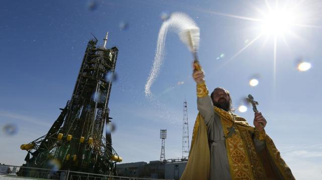 Un sacerdote ortodoxo hace una bendición frente a la nave espacial Soyuz TMA-14M (Reuters)