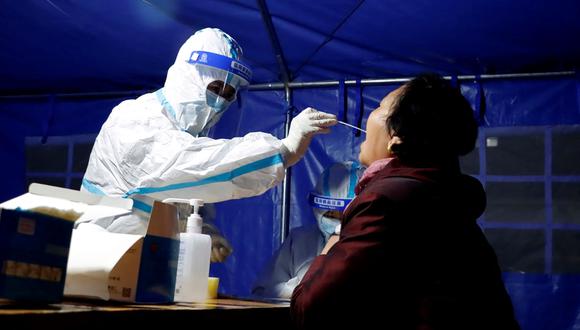 Esta foto tomada el 21 de octubre de 2021 muestra a un residente que se somete a una prueba de ácido nucleico para el coronavirus en Zhangye, en la provincia de Gansu, noroeste de China. (Foto de AFP)