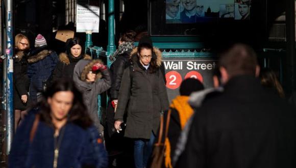 Un grupo de peatones caminan por Wall Street cerca a la bolsa de Nueva York (NYSE). (Foto: Bloomberg)