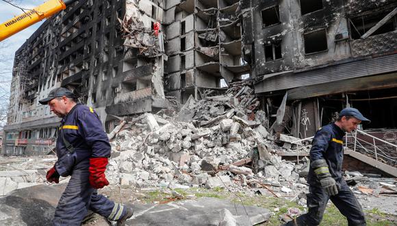 Los trabajadores de emergencia retiran los escombros de un edificio destruido en el transcurso del conflicto entre Ucrania y Rusia, en la ciudad portuaria sureña de Mariupol, Ucrania.