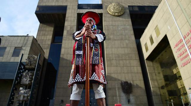 Un hombre vestido con trajes tradicionales da la bienvenida a los asistentes a la Cumbre de Cooperación Económica Asia-Pacífico, APEC (foto: AFP).