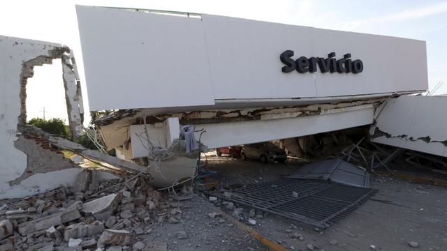 Foto 19 | Parte del edificio colapsado se encuentra precariamente sobre dos automóviles estacionados luego del terremoto en México. (Foto: AP)