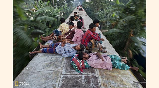 Bangladesíes duermen en el techo de un tren que los conduce a sus respectivos pueblos, en Dhaka, Bangladesh.