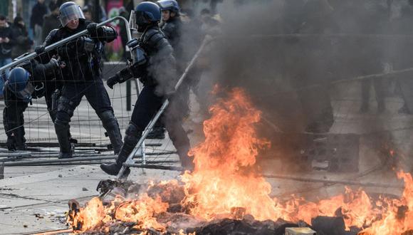Agentes de policía desmantelan una barricada en llamas durante una manifestación en Nantes, en el oeste de Francia, el 18 de marzo de 2023 (Foto: Loic Venance / AFP)