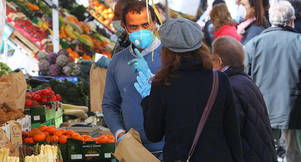 Las personas que usan máscaras faciales protectoras compran en un mercado abierto, en medio del cierre de emergencia por coronavirus, en Padua, Italia. (EFE/NICOLA FOSSELLA).