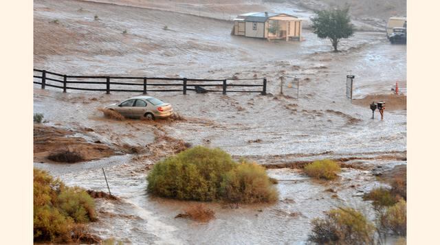Un vehículo intenta circular por una autopista inundada por un río desbordado en Hesperia, California. (Foto: AP)