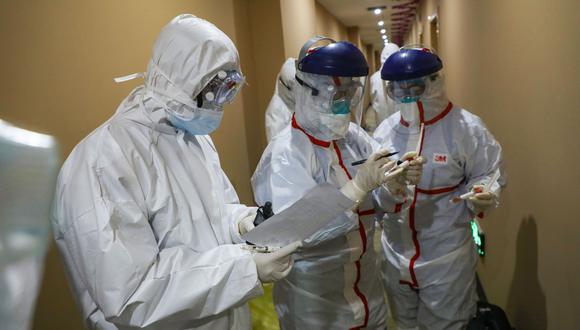 Médicos llevan una muestra tomada a una persona para analizar el nuevo coronavirus en una zona de cuarentena en Wuhan, el epicentro del brote. (AFP).