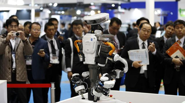 Los asistentes miran un robot industrial Kawada Robotics Corp. Nextage. La exposición corre a través de 05 de diciembre bajo el lema "hacer un futuro con robots ".