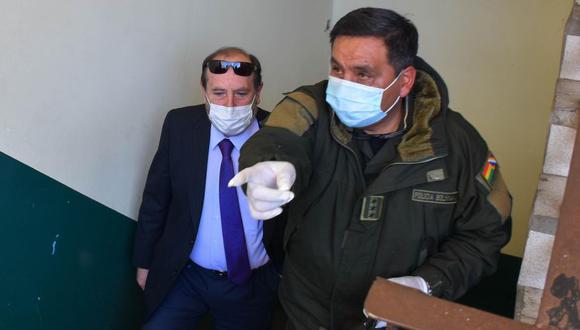 Policías de Bolivia custodian a Marcelo Navajas (izq.), quien fue arrestado en un caso de corrupción, tras lo que fue cesado del cargo de ministro de Salud del país andino. (Foto: EFE)