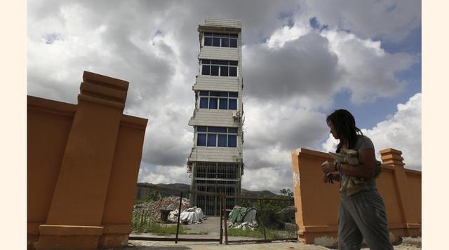 El propietario de esta "casa clavo" parcialmente derribada en la provincia de Rui'an, Zhejiang, vivió en ella durante casi un año después de que las autoridades locales le cortaron el suministro de agua y electricidad.  Desarrolladores habí