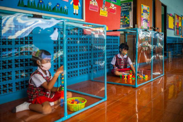 FOTO 1 | Los niños de la escuela Wat Khlong Toey en Bangkok (Tailandia) juegan en el interior de unas urnas preparadas para garantizar la distancia social. (Foto: Lauren DeCicca/Getty Images)