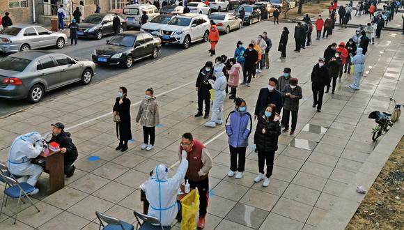 Los residentes hacen cola para someterse a pruebas de ácido nucleico para el coronavirus en Dalian, en la provincia nororiental china de Liaoning, el 16 de marzo de 2022. (Foto de AFP)