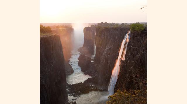 Cataratas Victoria, Zambia y Zimbabue. Conocidas desde antaño por las tribus limítrofes como Mosi-oa-Tunya (el humo que truena), las cataratas Victoria hacen honor a su nombre tribal por el ruido que originan las aguas del río Zambeze al caer, un salto de