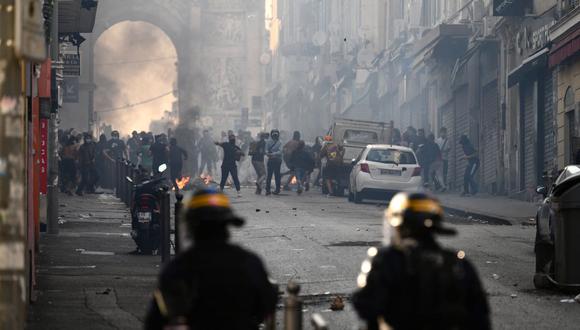 Los manifestantes chocan con la policía antidisturbios de CRS en la Porte d'Aix en Marsella, sur de Francia, el 30 de junio de 2023, por el tiroteo de un conductor adolescente por parte de la policía francesa en un suburbio de París el 27 de junio. (Foto de CHRISTOPHE SIMON / AFP)