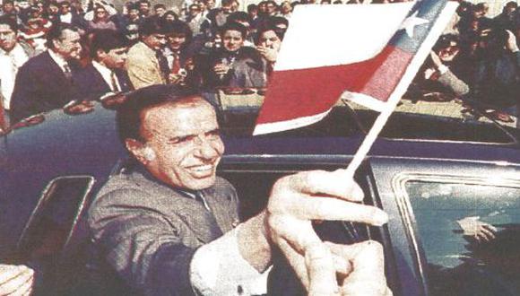 El presidente argentino Carlos Saúl Menem, con una bandera chilena en sus manos, saluda a los pobladores de un barrio obrero en Santiago de Chile, donde se encuentra en visita oficial (foto Reuter)