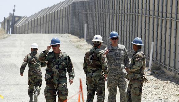 Miembros de la Guardia Nacional de California trabajando al lado de una cerca fronteriza con México. (Foto: AP)