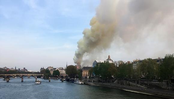 Las llamas y el humo se ven ondeando desde el techo de la Catedral de Notre-Dame en París. (Foto: AFP)
