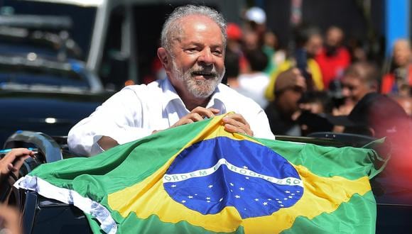 El presidente electo Luiz Inácio Lula da Silva sostiene una bandera brasileña al salir de un colegio electoral durante la segunda vuelta de las elecciones presidenciales en Sao Paulo, Brasil, el 30 de octubre de 2019. 2022. (Foto de CARL DE SOUZA / AFP)