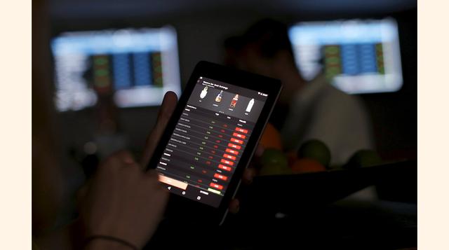 Una persona muestra en una tablet la aplicación que se utiliza en el Reserve Bar Stock Exchangela para pedir bebidas.  (Foto: Reuters)