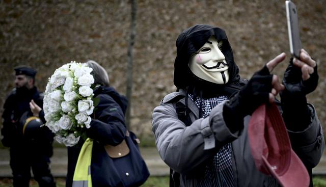 Un participante lleva una máscara y se toma una selfie mientras los miembros del movimiento "chaleco amarillo" se manifiestan en París. (Foto: AFP)