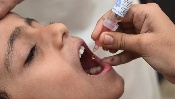 Un trabajador de la salud administra gotas de vacuna contra la polio a un niño durante una campaña de puerta en puerta. (Foto: AFP)