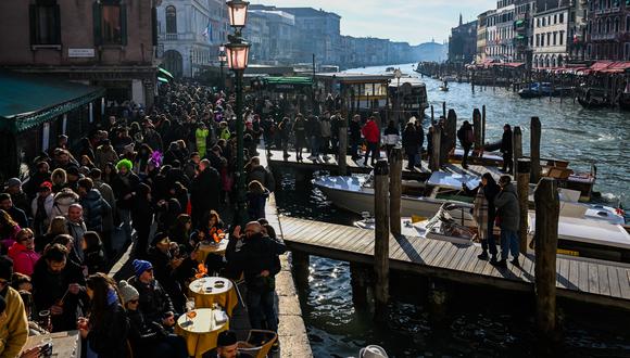 (ARCHIVOS) Visitantes y turistas se reúnen junto al Gran Canal durante el carnaval de Venecia el 11 de febrero de 2023. (Foto de Miguel MEDINA/AFP)